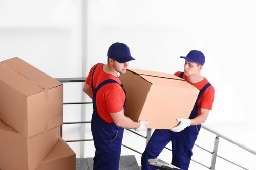A moving team carrying large furniture during Parsonsgreen furniture removals