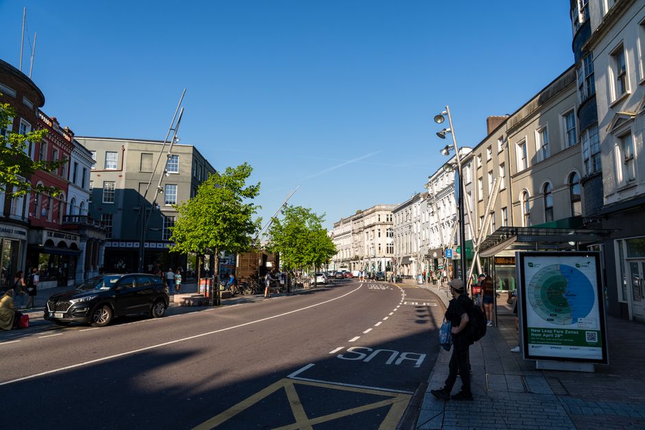 A white moving van with its rear doors open is parked on a street in Parsons Green, London, during the day. The van is positioned next to the sidewalk, with some cardboard boxes, plastic wrapping, and